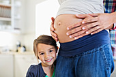 Girl smiling with pregnant mother's belly