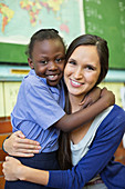 Teacher and student hugging in class