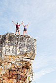 Climbers cheering on rocky cliff