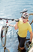 Man carrying mountain bike in river