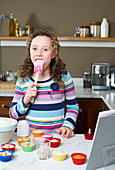 Girl licking spatula and baking