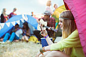 Woman text messaging at tent