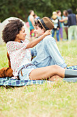 Couple hugging on blanket in grass