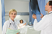 Doctors examining x-rays in hospital room