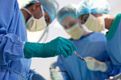 Surgeon holding knife in operating room