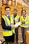 Businessman and workers in warehouse