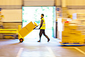 Blurred view of worker pushing boxes