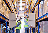 Workers carrying boxes in warehouse