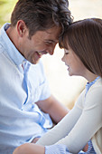 Father and daughter touching foreheads