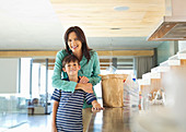 Mother hugging son in kitchen