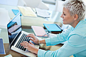 Businesswoman using laptop at desk