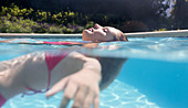 Woman floating in swimming pool