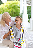 Woman wrapping granddaughter in towel