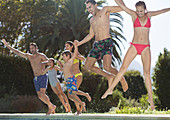 Family jumping into swimming pool