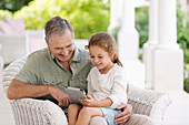 Older man and granddaughter using tablet