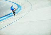 Track cyclist riding around velodrome