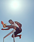 Track and field athlete clearing hurdle