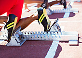 Runner's feet in starting blocks on track
