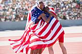 Track and field athletes wrapped in flag