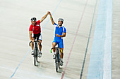 Track cyclists celebrating in velodrome