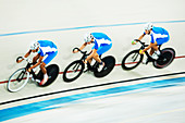 Track cycling team racing in velodrome