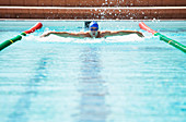 Swimmer racing in pool