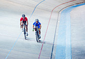 Track cyclists riding in velodrome