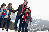 Happy family walking in snowy field