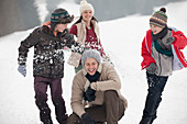 Playful family enjoying snowball fight