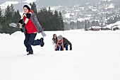 Mother and sons playing in snowy field