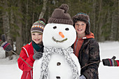 Boys posing with snowman