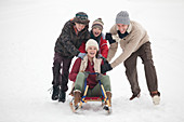 Happy family sledding in snow