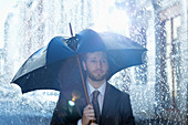 Businessman with broken umbrella