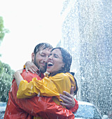 Happy couple hugging in rain