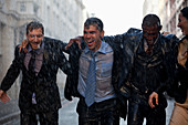 Happy businessmen walking in rainy street