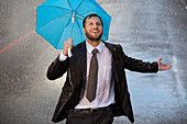 Businessman with tiny umbrella