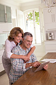 Senior couple using tablet in kitchen
