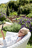 Senior woman using tablet in garden