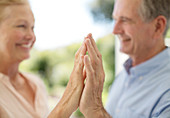 Senior couple touching hands on patio