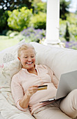Senior woman shopping online sofa