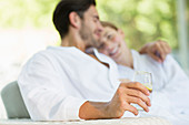 Couple in bathrobes hugging on patio