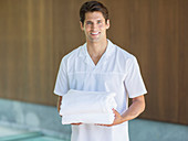 Waiter holding towels in spa