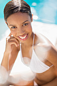 Smiling woman sitting poolside