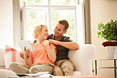 Couple using digital tablet on sofa