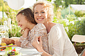 Mother and daughter smiling at table