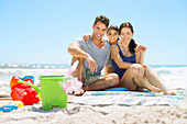 Smiling family sitting on beach