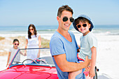 Father and son smiling on beach