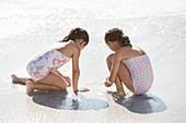 Girls playing together in surf on beach