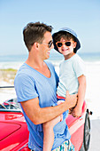 Father and son smiling on beach