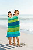 Girls wrapped in towel on beach